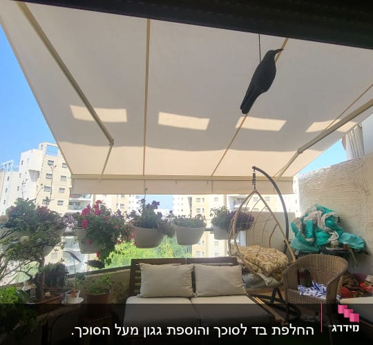 סוכך לבן גדול מעל מרפסת עם צמחים תלויים